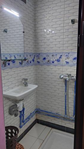 a bathroom with a sink and blue and white tiles at IAZAL Hotel Ouarzazate in Ouarzazate