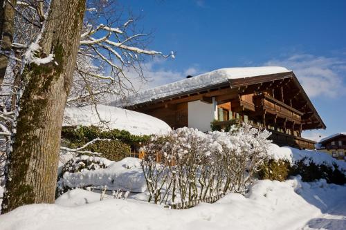 a house covered in snow in front at Haus Garden in Ellmau