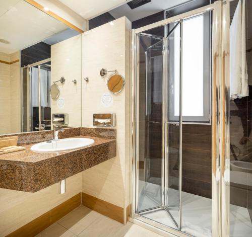uma casa de banho com um lavatório e um chuveiro em Ilunion Les Corts Spa em Barcelona