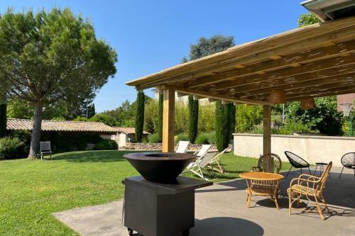 - un barbecue dans un jardin avec une pergola en bois dans l'établissement La Belle Etoile - Convivial house with a relaxed holiday atmosphere, à Saint-Didier-au-Mont-dʼOr
