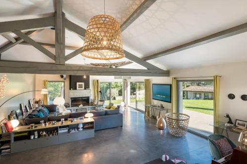 d'un salon avec un grand canapé et un lustre. dans l'établissement La Belle Etoile - Convivial house with a relaxed holiday atmosphere, à Saint-Didier-au-Mont-dʼOr