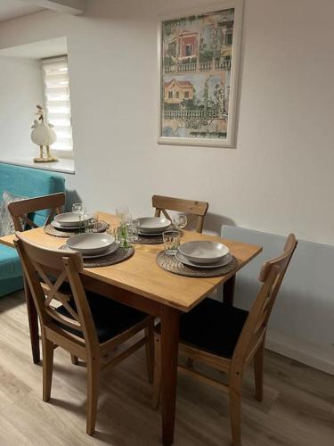 - une table en bois avec des chaises et des assiettes dans l'établissement Chez Mat - 4 pers - Proche Obernai, à Bernardswiller