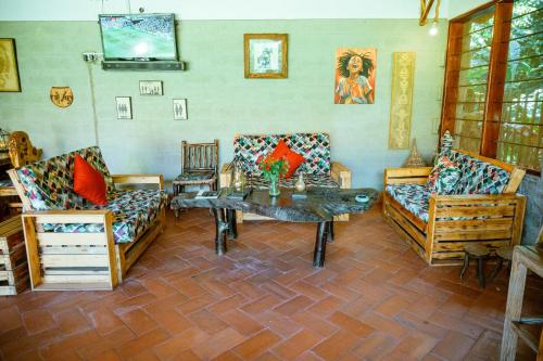 Sala de estar con 2 sofás y mesa en Kisubi Forest Cottages en Entebbe