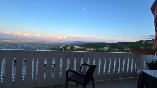 a chair sitting on a balcony with a view at Guest House Maria in Sighnaghi
