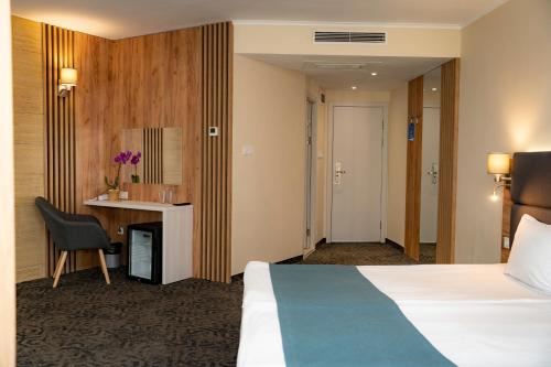 a hotel room with a bed and a desk at Aqua Hotel in Burgas City