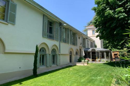 a large white building with a yard in front of it at Les Gargouilles - House with crazy charm heated pool and garden in Caluire-et-Cuire