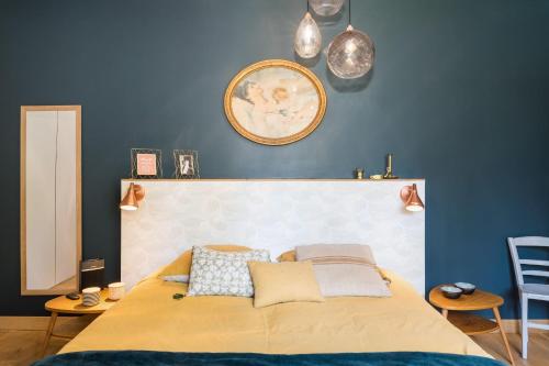 a bedroom with a bed and a blue wall at Les Gargouilles - House with crazy charm heated pool and garden in Caluire-et-Cuire