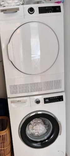 a white washer and dryer with its door open at Beach Front Apartment in Netanya