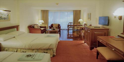 una camera d'albergo con due letti e un soggiorno di Purimas Beach Hotel & Spa a Ban Chang