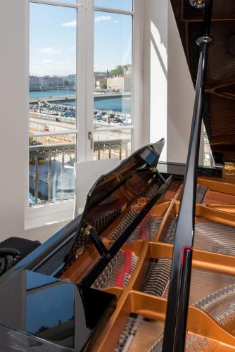 - un piano dans une chambre avec vue sur le port dans l'établissement Le Trompettiste - Newly refurbished flat, à Lyon