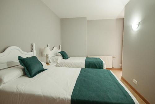 a bedroom with two beds with green and white at LAR DA REVOLTA in Cedeira