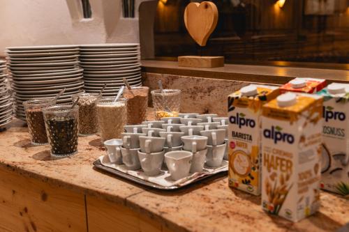 a counter with cups and plates and a box of coffee at Haus Garden in Ellmau