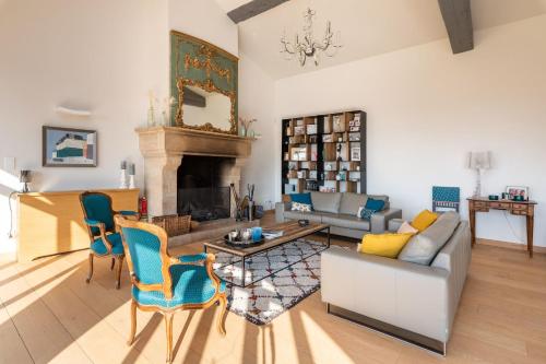 un salon avec un canapé et une cheminée dans l'établissement Les Voutes - Beautiful property with swimming pool, à Saint-Didier-au-Mont-dʼOr