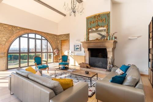 un salon avec un canapé et une cheminée dans l'établissement Les Voutes - Beautiful property with swimming pool, à Saint-Didier-au-Mont-dʼOr