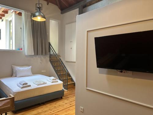 a bedroom with a flat screen tv attached to a wall at Belle Athenes - Luxury Rooms at Monastiraki Railway Station in Athens