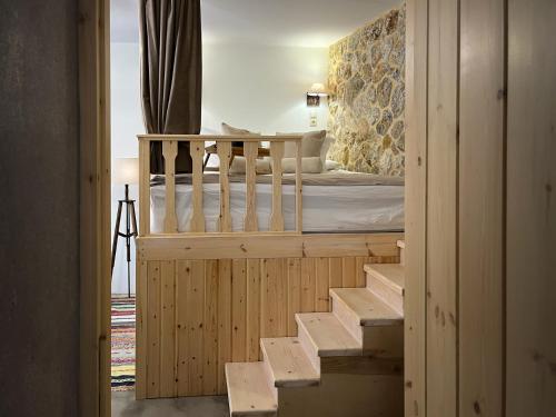 een slaapkamer met een stapelbed en een trap naar een kamer bij stonehousekefalos in Kefalos