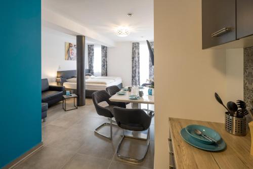 una cucina e un soggiorno con tavolo e sedie di Motel24seven a Bruck an der Mur