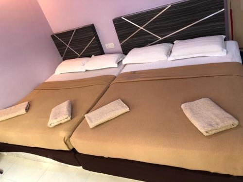 a bedroom with a large bed with two pillows at Al Huda Hotel in Malacca