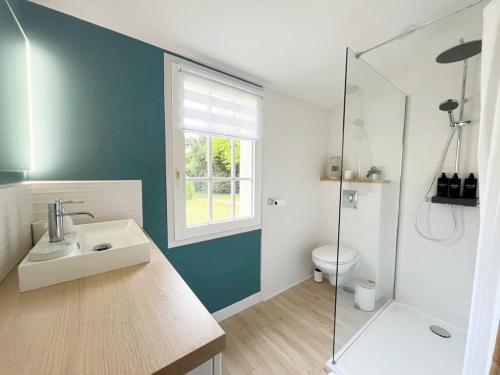 une salle de bain avec un lavabo et une douche en verre dans l'établissement Superbe longère 4 étoiles à 2 pas de la mer, à Château-dʼOlonne