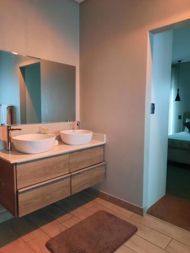 Luxury holiday home 3 bedroom, 3 bathroom house in Nahoon في شرق لندن: حمام به مغسلتين ومرآة كبيرة