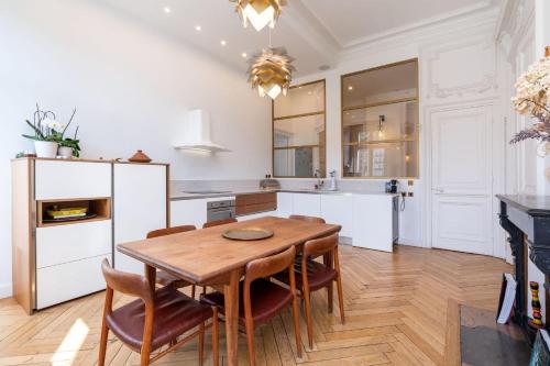 une cuisine avec une table et des chaises en bois dans l'établissement Les balcons de Fourvière - Apartment with view, à Lyon
