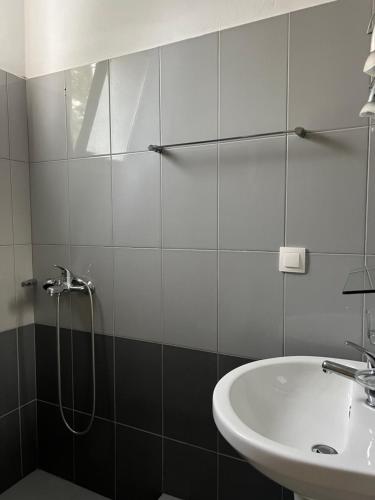 a bathroom with a sink and a shower at Guesthouse Butrinti in Ksamil
