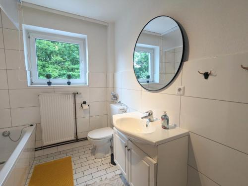 a white bathroom with a sink and a mirror at Monteur Atelier in Marl