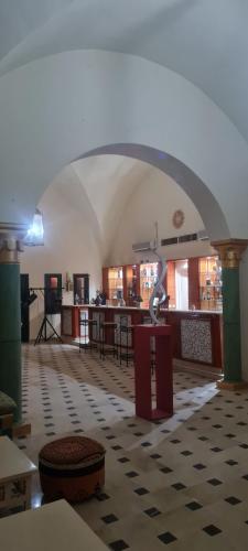 Qaşr Ghīlān的住宿－Hotel Pansy，一间设有拱门的房间和一张桌子