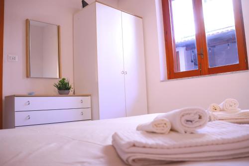 a white bedroom with towels on a bed at La Torre guest house in Acireale