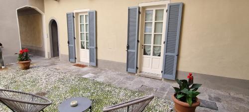 una casa con puertas azules, sillas y plantas en Suite Arianna, en Cannobio