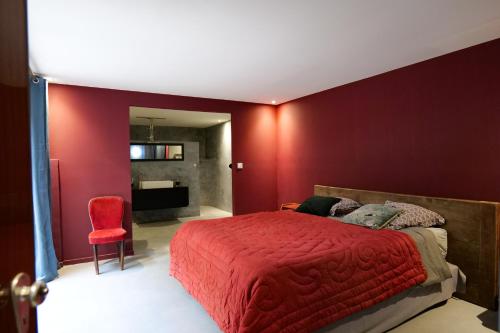 une chambre rouge avec un lit et un mur rouge dans l'établissement Maison exceptionnelle esprit loft avec piscine, à Pézenas