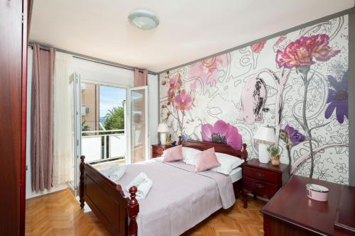 una camera con un letto con una parete floreale di Apartmani Jakov a Podstrana