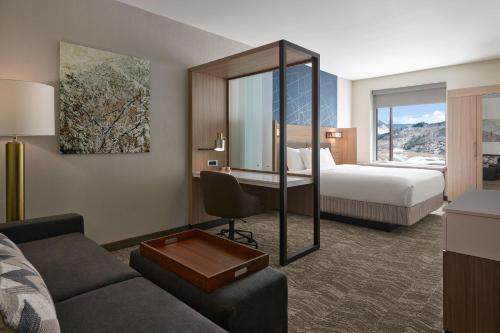 SpringHill Suites by Marriott Avon Vail Valley في آفون: غرفة في الفندق مع أريكة وسرير