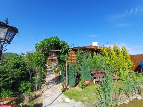 a garden with plants and a house in the background at У Фёдера и Маргариты in Nizhnyaya Grabovnitsa