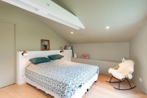 une chambre avec un lit et une chaise dedans dans l'établissement Souvenirs architect's house with pool and garden, à Écully
