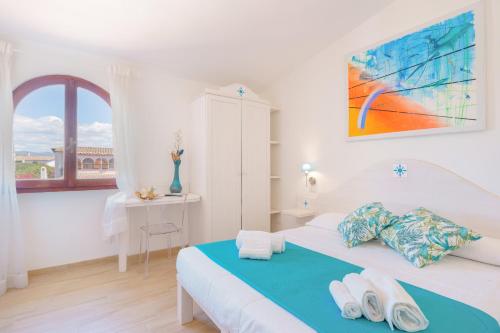 a white bedroom with a bed with towels on it at B&B Villamarina42 in Flumini di Quartu