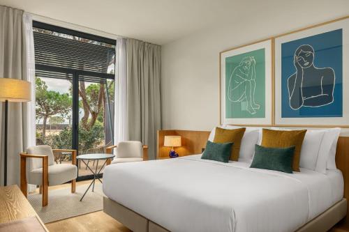 um quarto de hotel com uma cama e uma grande janela em AC Hotel Gava Mar em Gavà