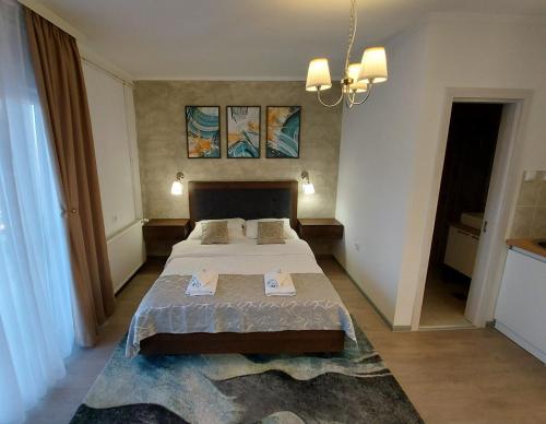 um quarto com uma cama grande e um lustre em Apartments Marina em Apatin