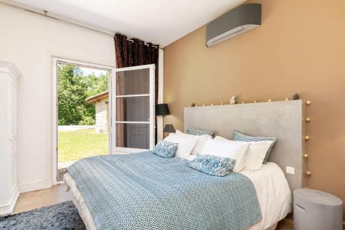 a bedroom with a bed and a large window at Le Mas - House with swimming pool in a privileged environment in Saint-Didier-au-Mont-dʼOr