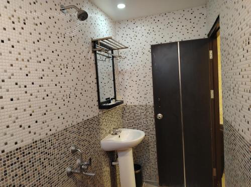 W łazience znajduje się umywalka i prysznic. w obiekcie Coastal Grand Hotel Sampath w mieście Tiruchchirāppalli