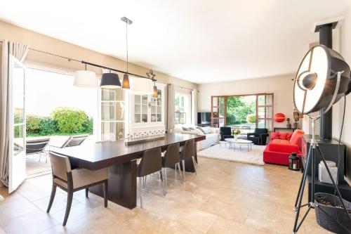 une salle à manger et un salon avec une table et des chaises dans l'établissement Le Mas - House with swimming pool in a privileged environment, à Saint-Didier-au-Mont-dʼOr