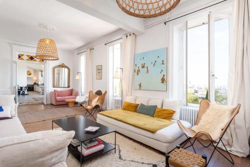 Elle comprend un salon doté d'un mobilier blanc et de grandes fenêtres. dans l'établissement La vue - Charming house with a pool garden and amazing view, à La Mulatière