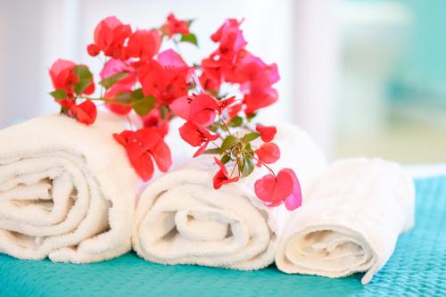 a group of towels with red flowers on them at B&B Villamarina42 in Flumini di Quartu