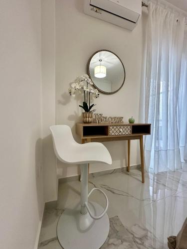 a white desk with a white chair and a mirror at Eleni's Green balcony modern apartment by the Sea in Loutraki