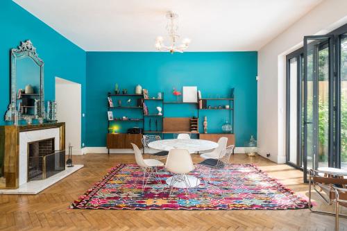 - un salon avec des murs bleus, une table et des chaises dans l'établissement Hôtel Particulier Vintage and and design house with pool, à Lyon