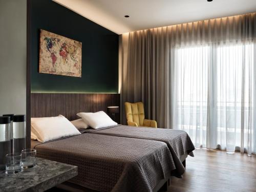 - une chambre avec un lit et une grande fenêtre dans l'établissement Candia Hotel, à Athènes
