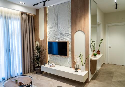 a living room with a tv on a wall at ProGarden Luxury Apartments Tirana in Tirana