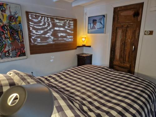 een slaapkamer met een bed met een zwart-witte deken bij Pantheos Top Houseboat in Amsterdam