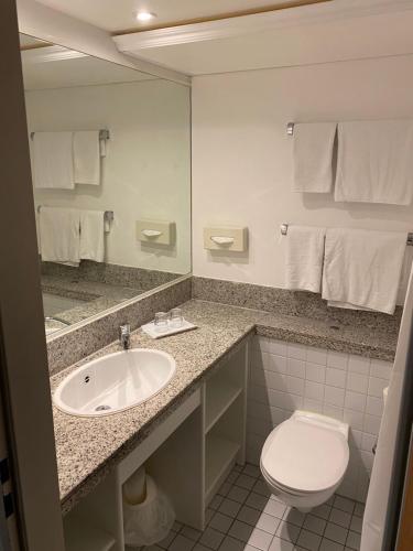 a bathroom with a sink and a toilet and a mirror at Hotel B99 in Offenbach