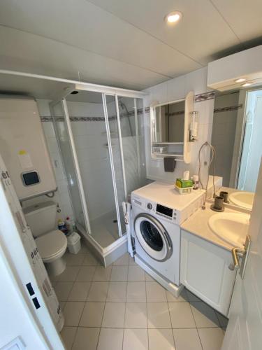 une salle de bain avec une machine à laver et un lavabo dans l'établissement 2 pièces bord de mer, à Vallauris